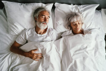 Old man and woman sleeping in a bed together