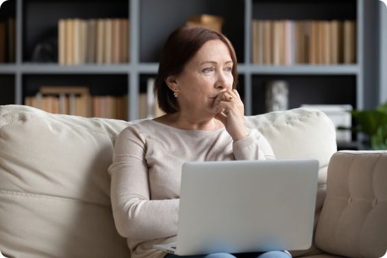 Women sitting on a couch with laptop - Restless Legs Syndrome